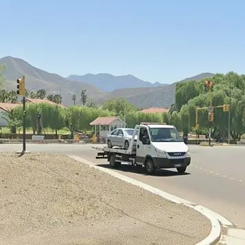 Grúa remolcando un auto gris por avenida ingresando a Mendoza